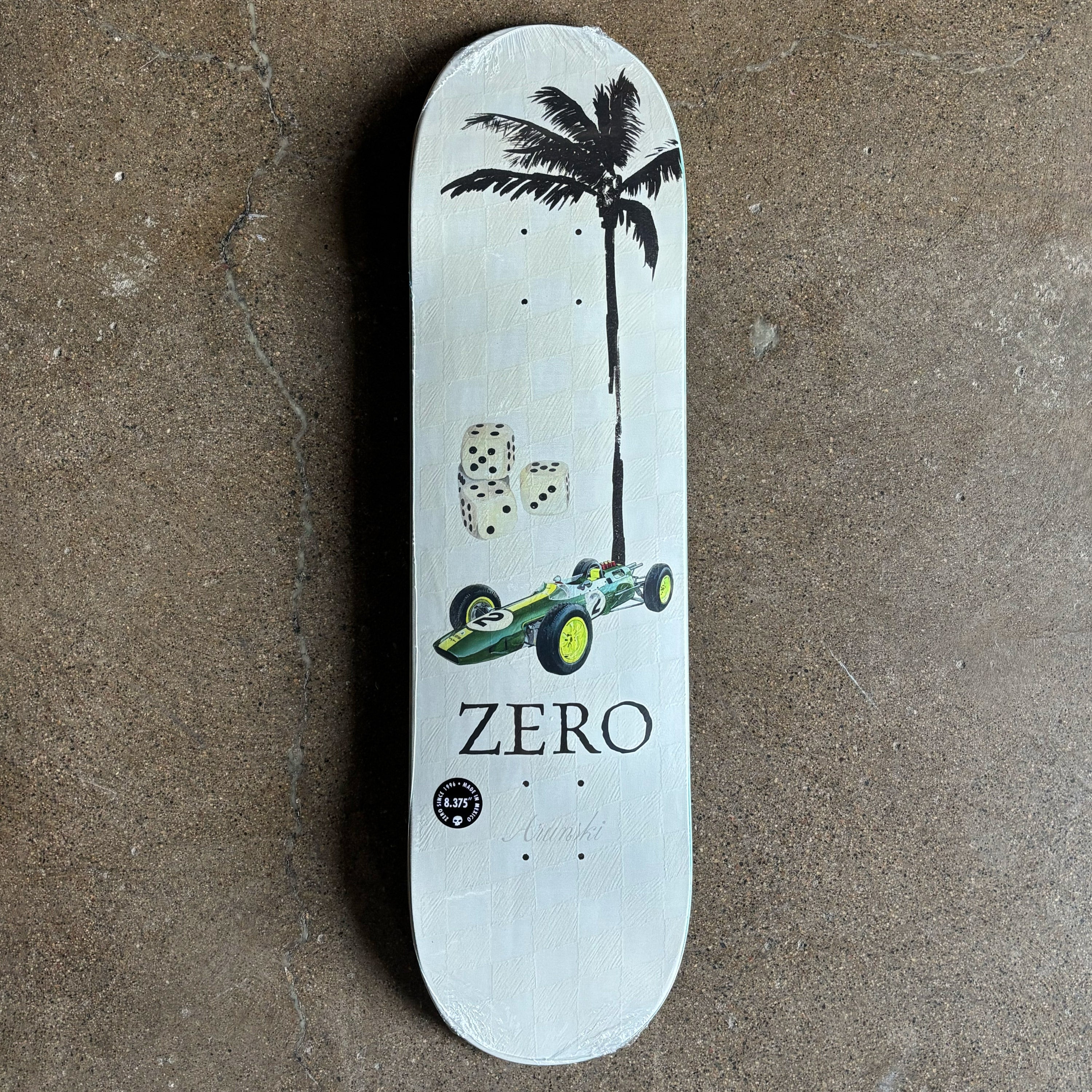 Skateboard deck with a palm tree and car art.